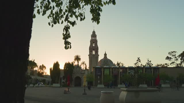 A park, palm trees and the buildings in Balboa Park, with people walking.
