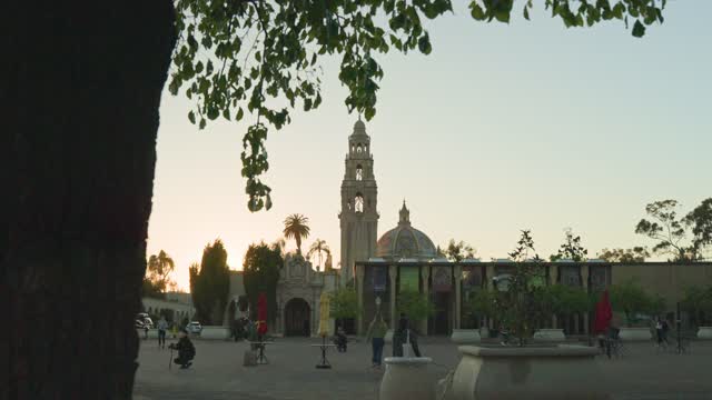 A park, palm trees and the buildings in Balboa Park, with people walking.