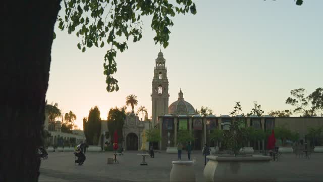 A park, palm trees and the buildings in Balboa Park, with people walking.