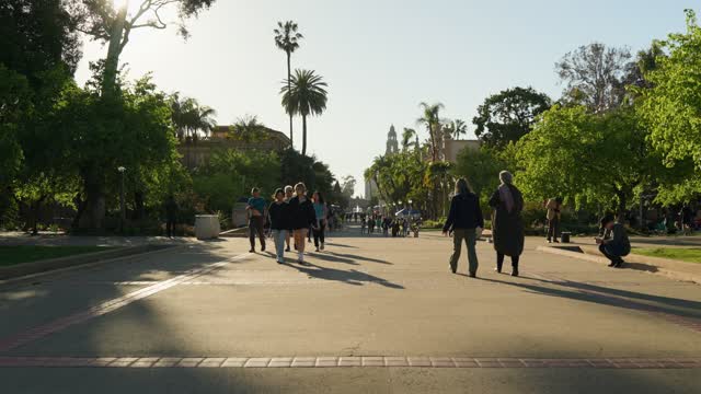 A park, palm trees and the buildings in Balboa Park, with people walking.