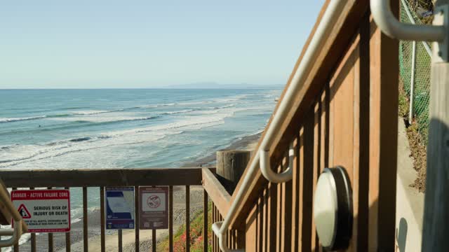 Elevated view of the cliffs, the surf and the ocean in Encinitas, with surfers out.