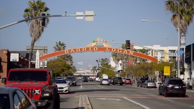The downtown streets, palm trees and the buildings in Barrio Logan, with people walking.
