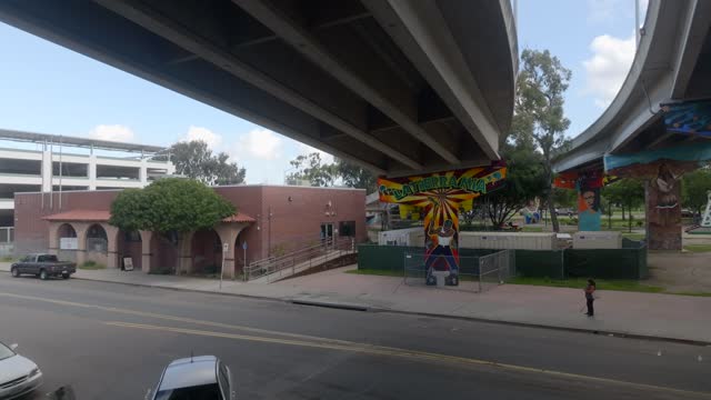 The downtown streets, the bridge and homes in Barrio Logan, with people walking.