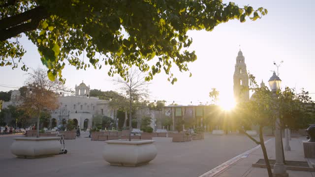 A park, palm trees and the buildings in Balboa Park, with people walking.