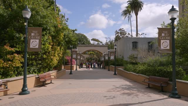 A park, palm trees and the buildings in Balboa Park, with people walking.