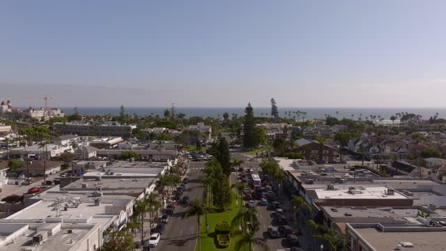 Low aerial view of the downtown streets, palm trees and the ocean in Coronado.