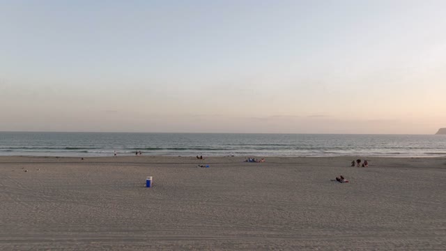 The beach, the ocean and open country at Coronado Beach, with a crowd gathered.