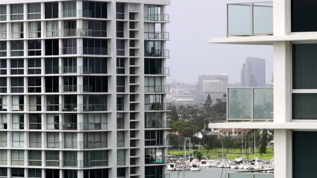 Low aerial view of a residential street, the skyline and boats at Coronado Beach.