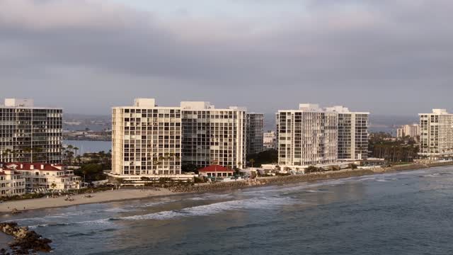 Low aerial view of the beach, the ocean and homes at Coronado Beach.