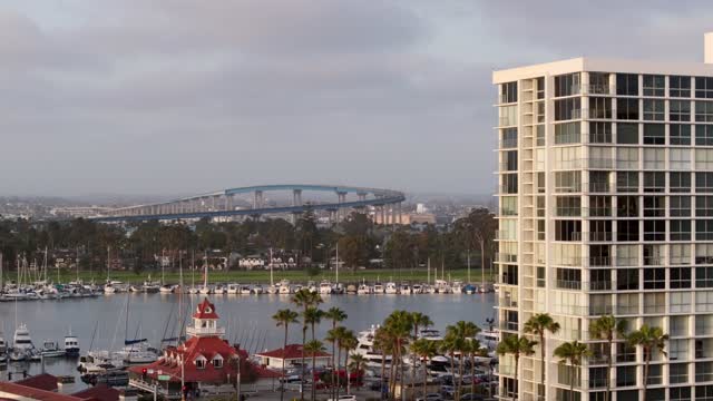 Low aerial view of the harbor, the bridge and boats at Coronado Beach, with boats out.