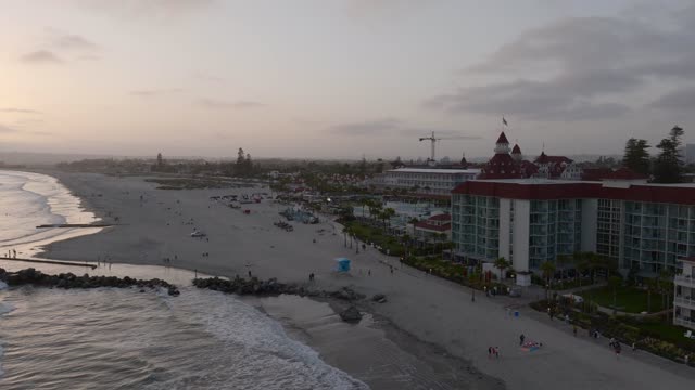 Aerial view of the beach, the ocean and homes at Coronado Beach, with people walking.
