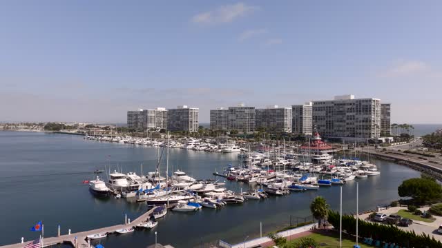 Low aerial view of the harbor, boats and palm trees at Coronado Beach, with boats out.