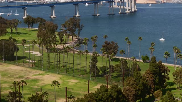 Flying towards the Coronado Bridge over the Golf Course and Glorietta Bay in San Diego during twilight | Drone Video – 1