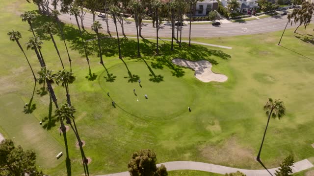 Aerial view of a park, palm trees and homes at Glorietta Bay, with people walking.