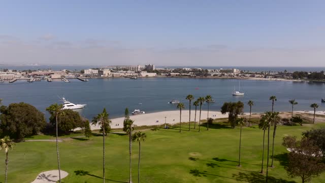 Low aerial view of the harbor, boats and palm trees at Glorietta Bay, with boats out.
