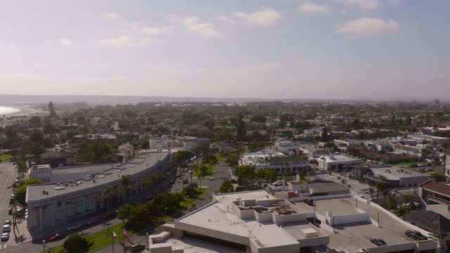 Low aerial view of a residential street, the ocean and homes at Coronado Beach.