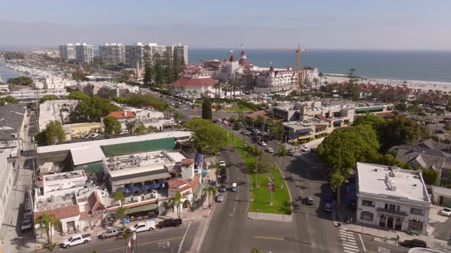 Aerial view of the downtown streets, palm trees and the ocean at Coronado Beach, with people walking.