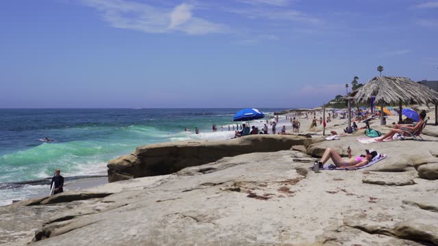 The beach, the surf and the ocean at Windansea, with a crowd gathered.