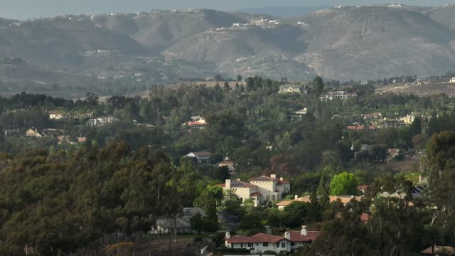 Aerial view of a residential street, homes and open country in Rancho Santa Fe.