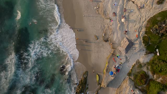 Aerial view of the beach, the surf and the ocean at Beach Barber Tract, with people walking.