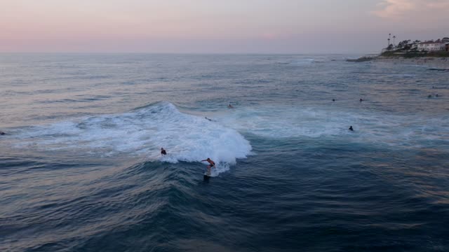 Low aerial view of the beach, the surf and the ocean at Beach Barber Tract, with surfers out.