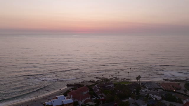 Aerial view of the beach, the surf and palm trees at Beach Barber Tract, with people walking.