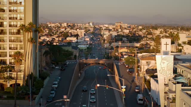 Low aerial view of the downtown streets, the bridge and palm trees in North Park, with people walking.