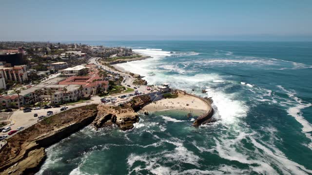 Aerial view of the cliffs, the surf and palm trees at La Jolla Cove.