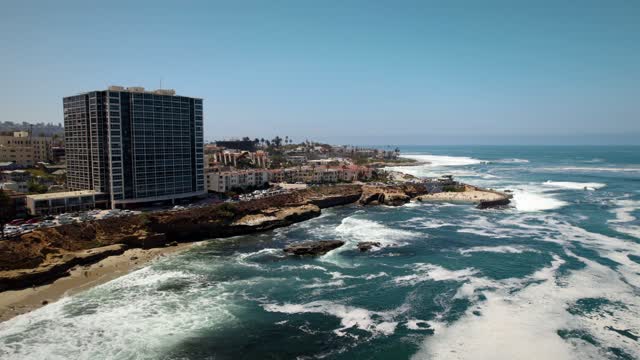 Aerial view of the cliffs, the surf and the ocean at La Jolla Cove.