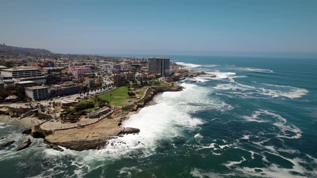 Aerial view of the cliffs, the surf and the ocean at La Jolla Cove.