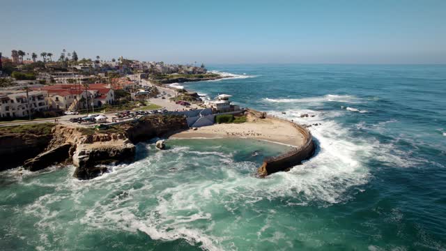 Aerial view of the cliffs, the surf and palm trees at La Jolla Cove.