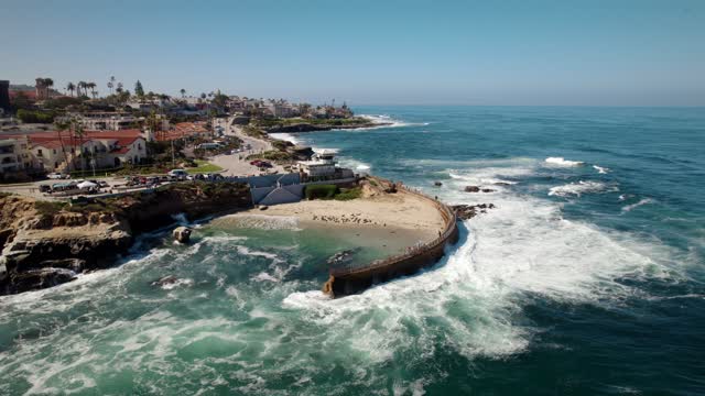 Aerial view of the cliffs, the surf and boats at La Jolla Cove.