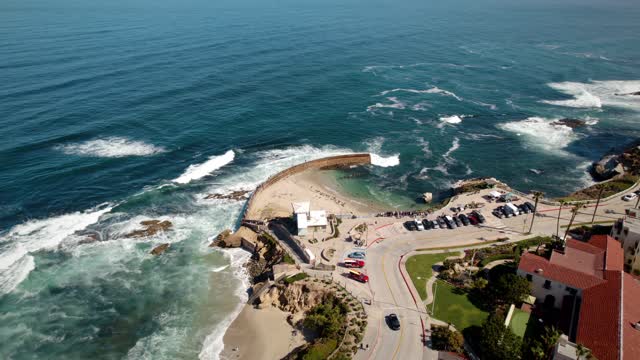 Aerial view of the cliffs, the surf and the ocean at La Jolla Cove.