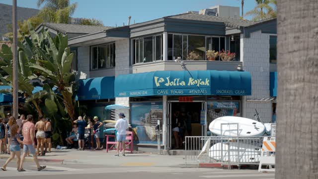 The downtown streets, palm trees and the buildings at La Jolla Shores, with people walking.