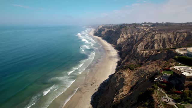 Aerial view of the cliffs, the surf and the ocean at Black’s Beach.