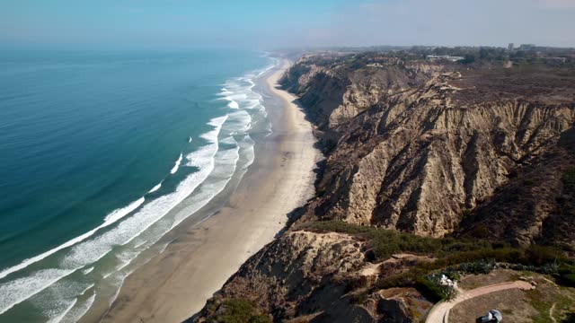 Aerial view of the cliffs, the surf and the ocean at Black’s Beach.