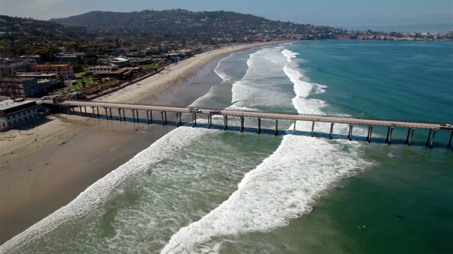 Aerial view of the beach, the surf and the pier at La Jolla Shores.
