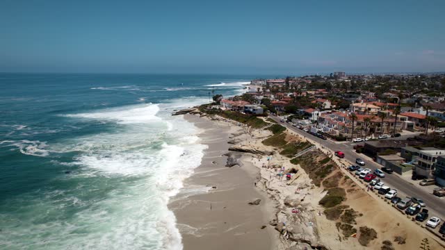 Aerial view of the beach, the surf and the ocean at Windansea, with people walking.