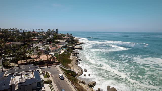 Aerial view of the cliffs, the surf and palm trees at Windansea.
