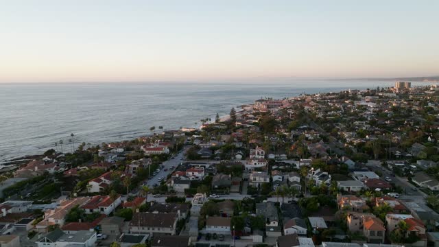 Aerial view of a residential street, palm trees and the ocean at Beach Barber Tract.
