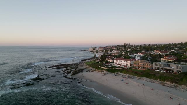 Aerial view of the beach, the ocean and homes at Beach Barber Tract, with people walking.