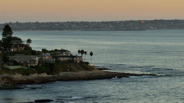 Low aerial view of the cliffs, palm trees and the ocean at Beach Barber Tract.