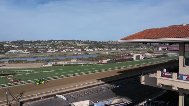 Low aerial view of the country inland, the buildings and traffic in Del Mar, with a work crew on site.