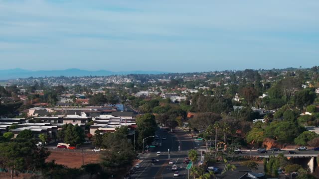 Low aerial view of a residential street, homes and the city at Del Mar Dog Beach.