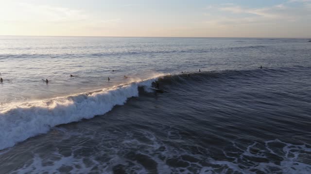 Low aerial view of the beach, the surf and the ocean at Bird Rock, with surfers out.