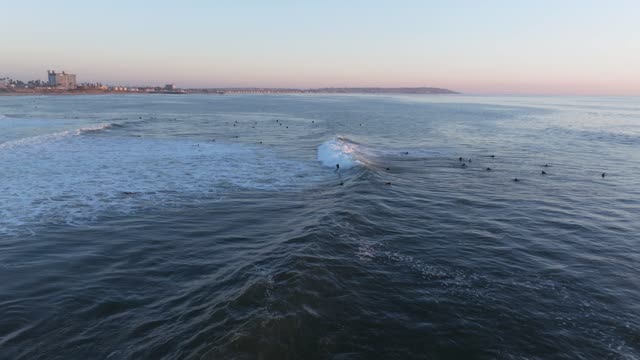Low aerial view of the beach, the surf and the ocean at Bird Rock, with surfers out.