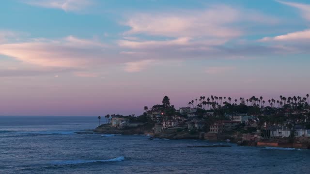 Low aerial view of the cliffs, the surf and palm trees at Bird Rock.