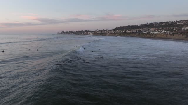 Low aerial view of the beach, the surf and the ocean at Bird Rock, with surfers out.