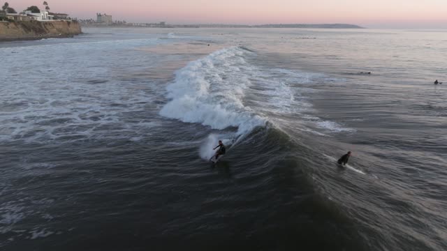 Low aerial view of the beach, the surf and the ocean at Bird Rock, with surfers out.
