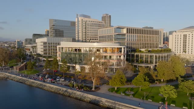 Low aerial view of the downtown streets, the skyline and palm trees at Embarcadero, with people walking.